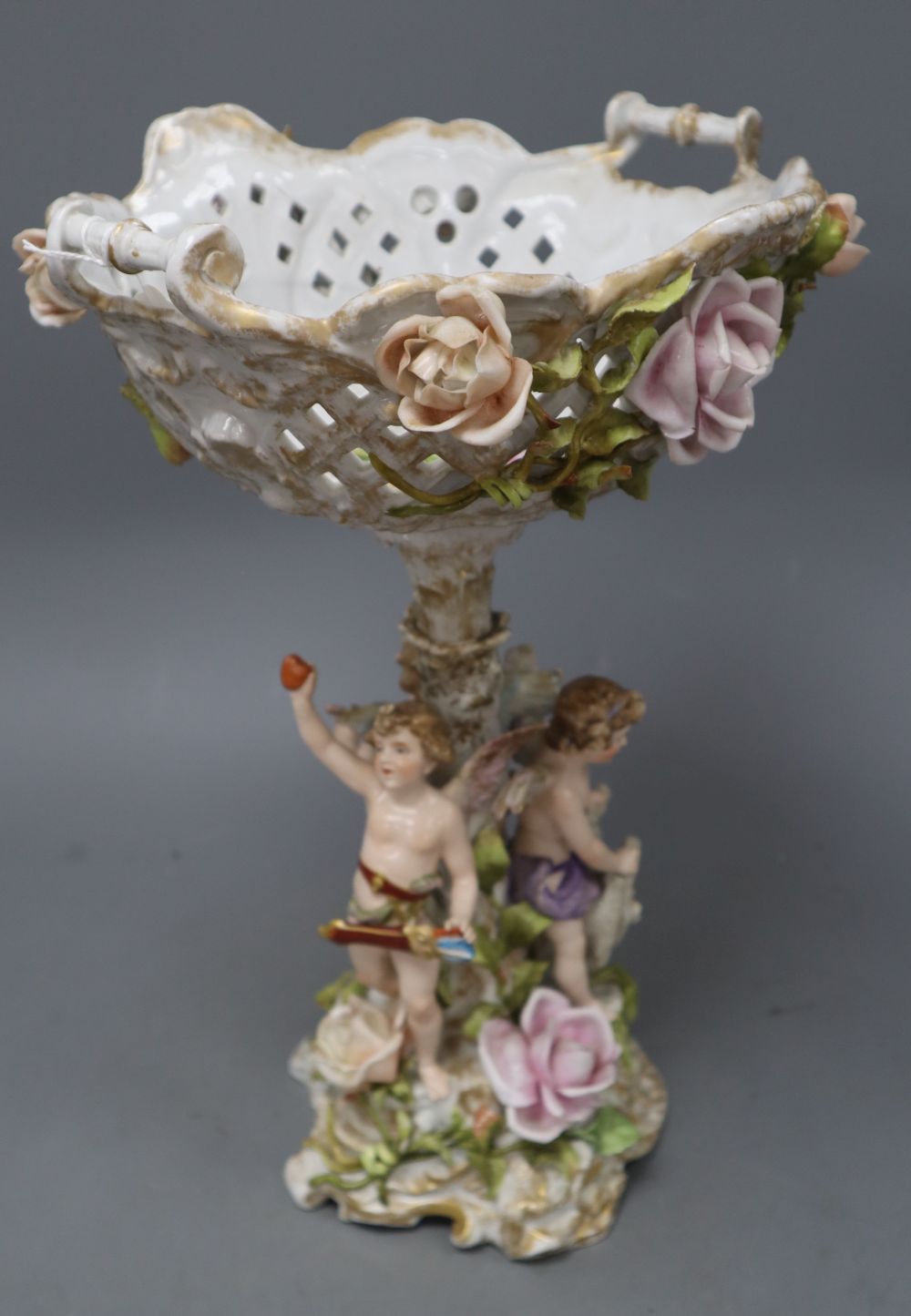 A Sitzendorf floral encrusted porcelain fruit stand, on a figural support, overall height 40cm